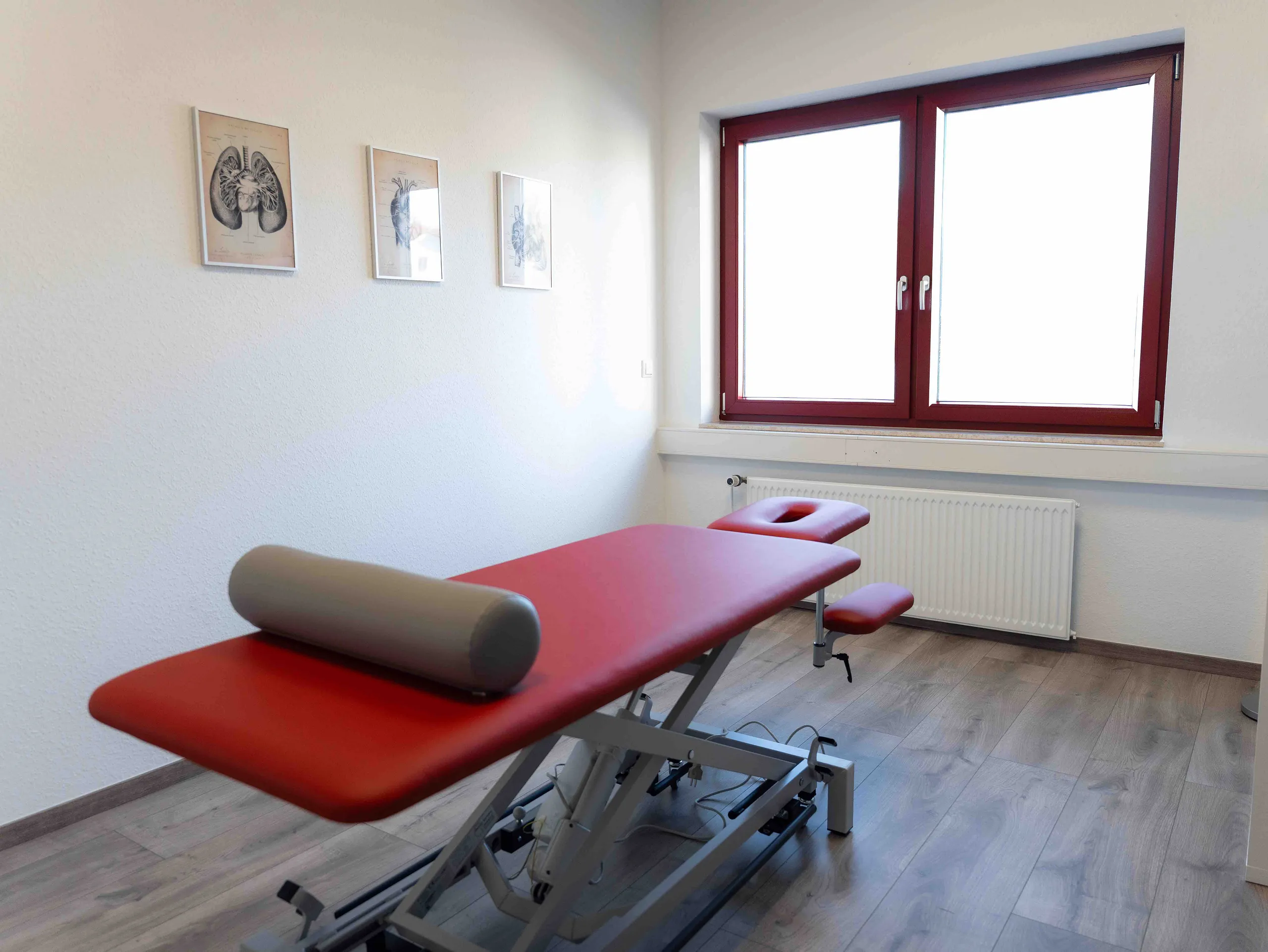 Behandlungsraum mit kirschroter Behandlungsliege